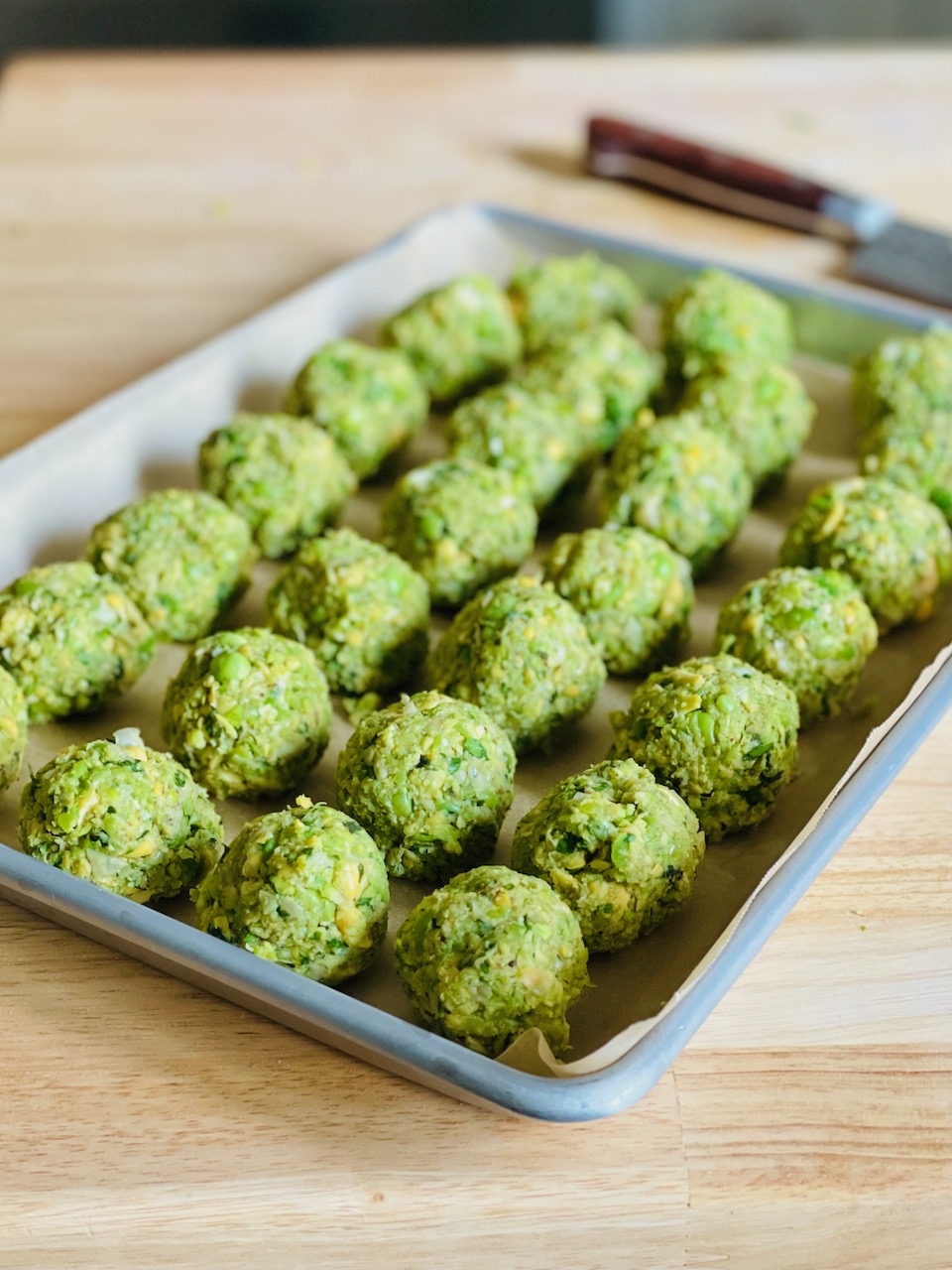 Photo of a tray of prepared falafel balls before frying.