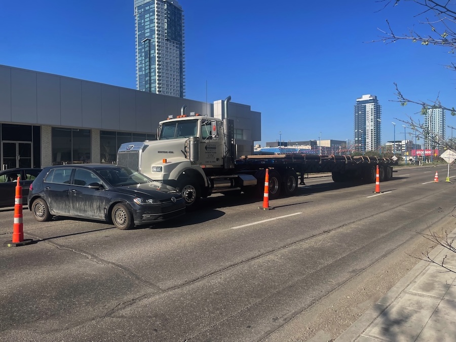A Volkswagen Golf is perpendicular to the front of a large semi truck that crashed into it.